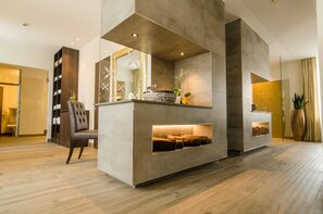 A modern interior with a seating area, a fireplace, and a large mirror.