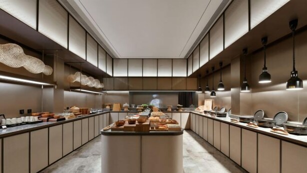 A modern kitchen with a central island, long countertops, and pendant lighting. - JOYA Hotel Jia Ding (Shanghai)