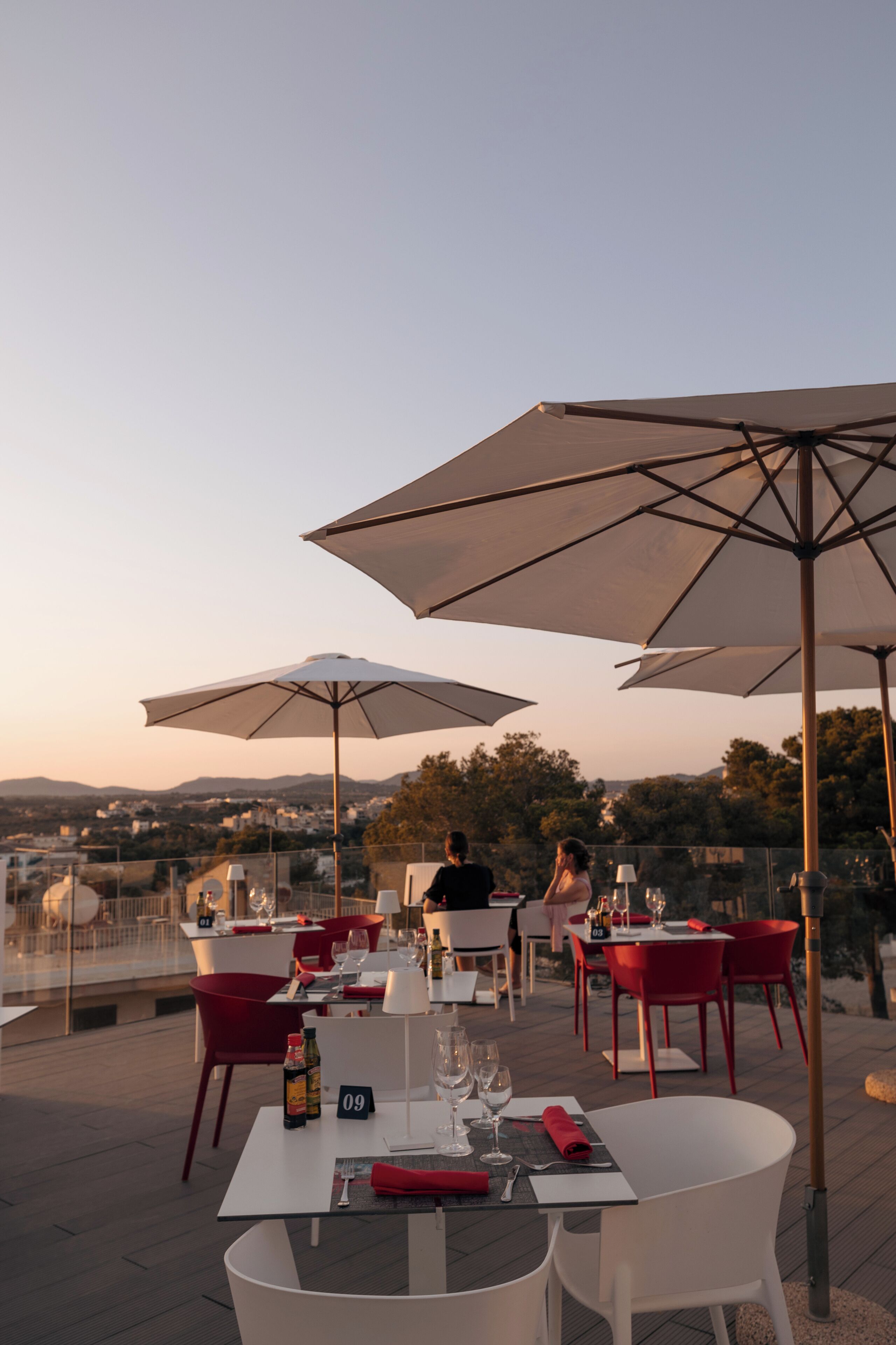 An outdoor dining area with tables, chairs, and umbrellas.