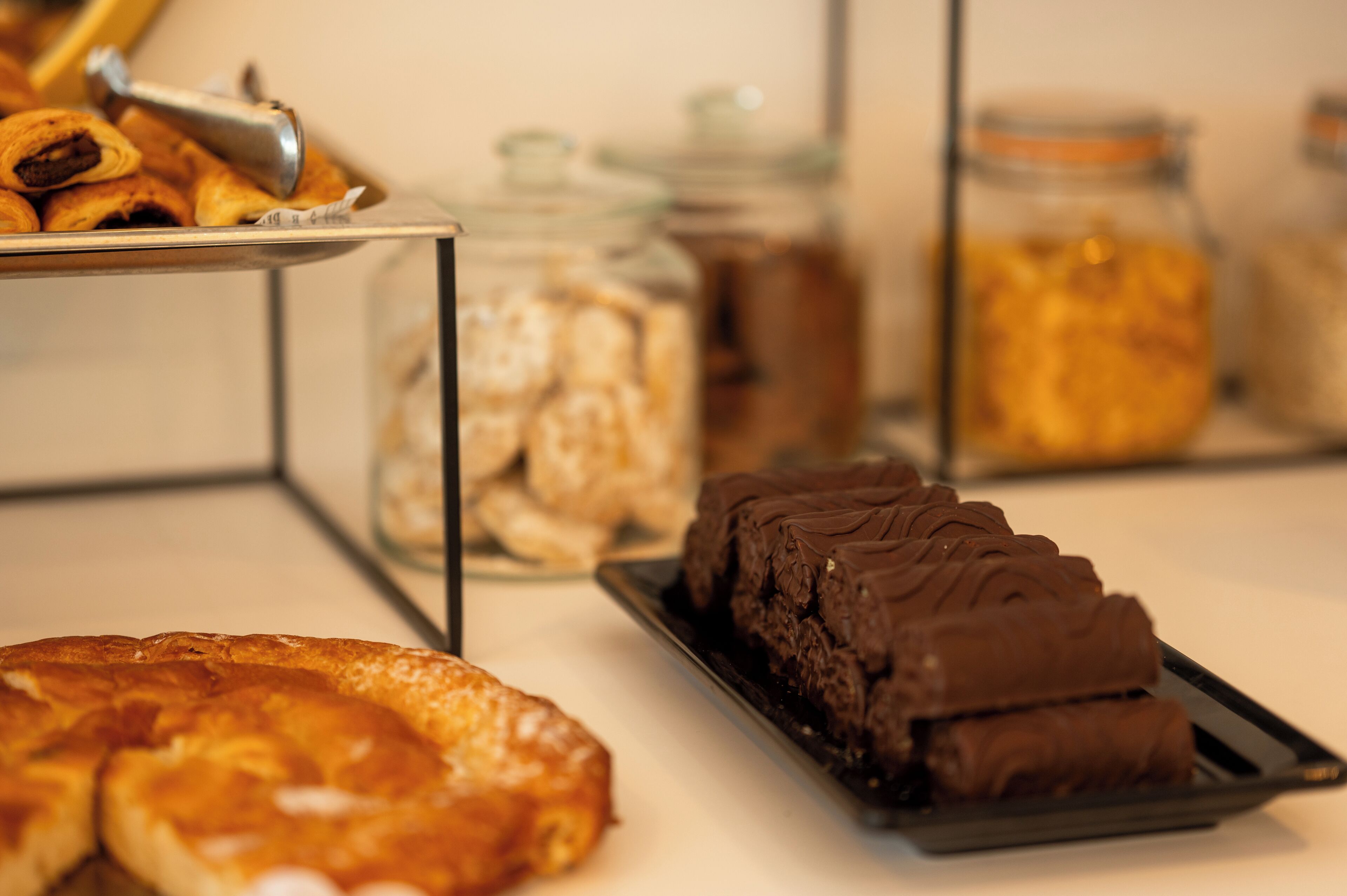 Un bufé con diversas opciones de panadería y postres, incluyendo pasteles y bizcochos de chocolate.