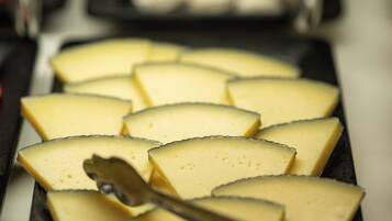 Una bandeja de rebanadas de queso con un cuchillo para queso.