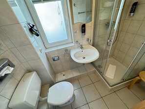 A bathroom with a toilet, sink, and shower.