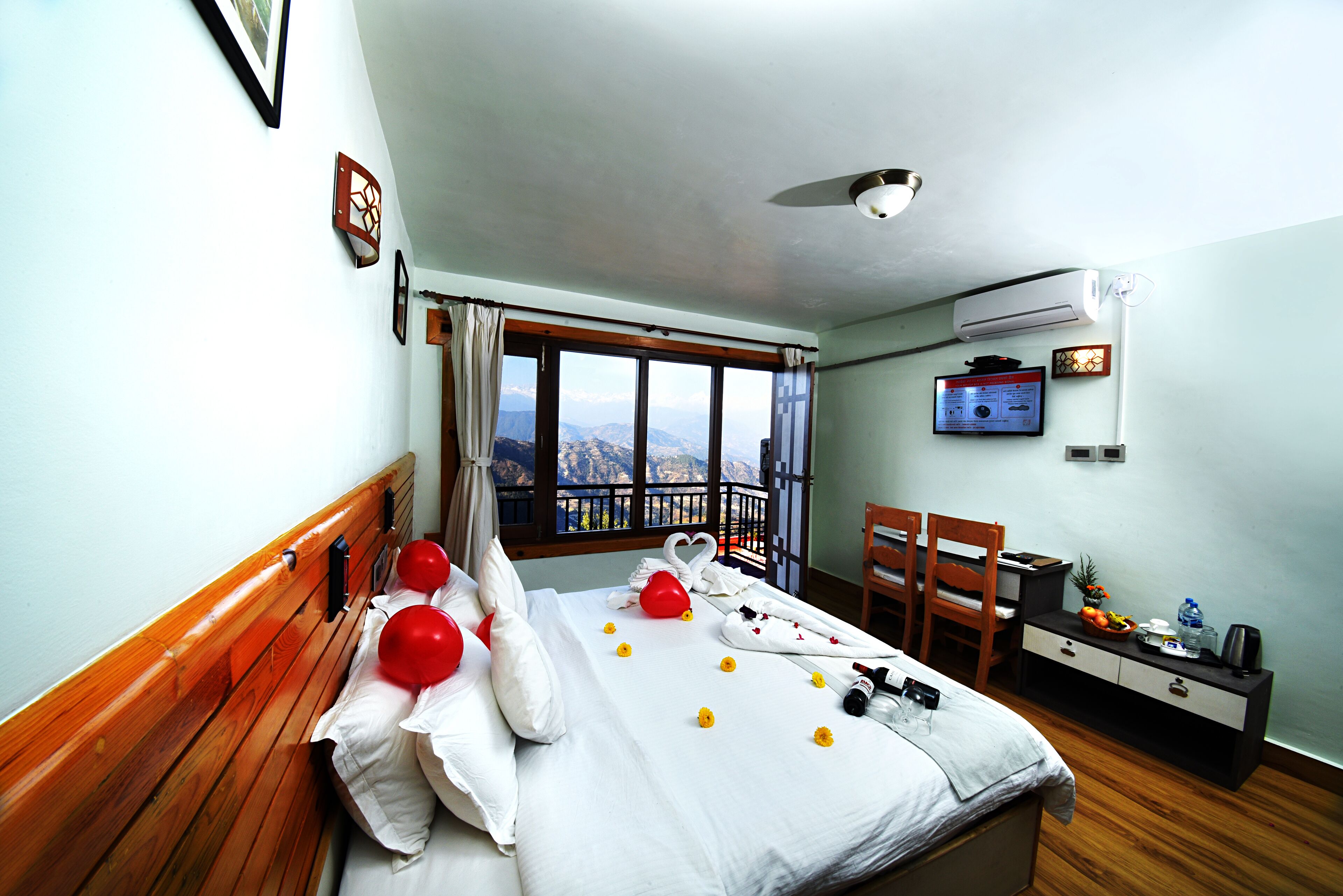 Habitación de hotel con cama, escritorio, silla, ventana con vistas y aire acondicionado.