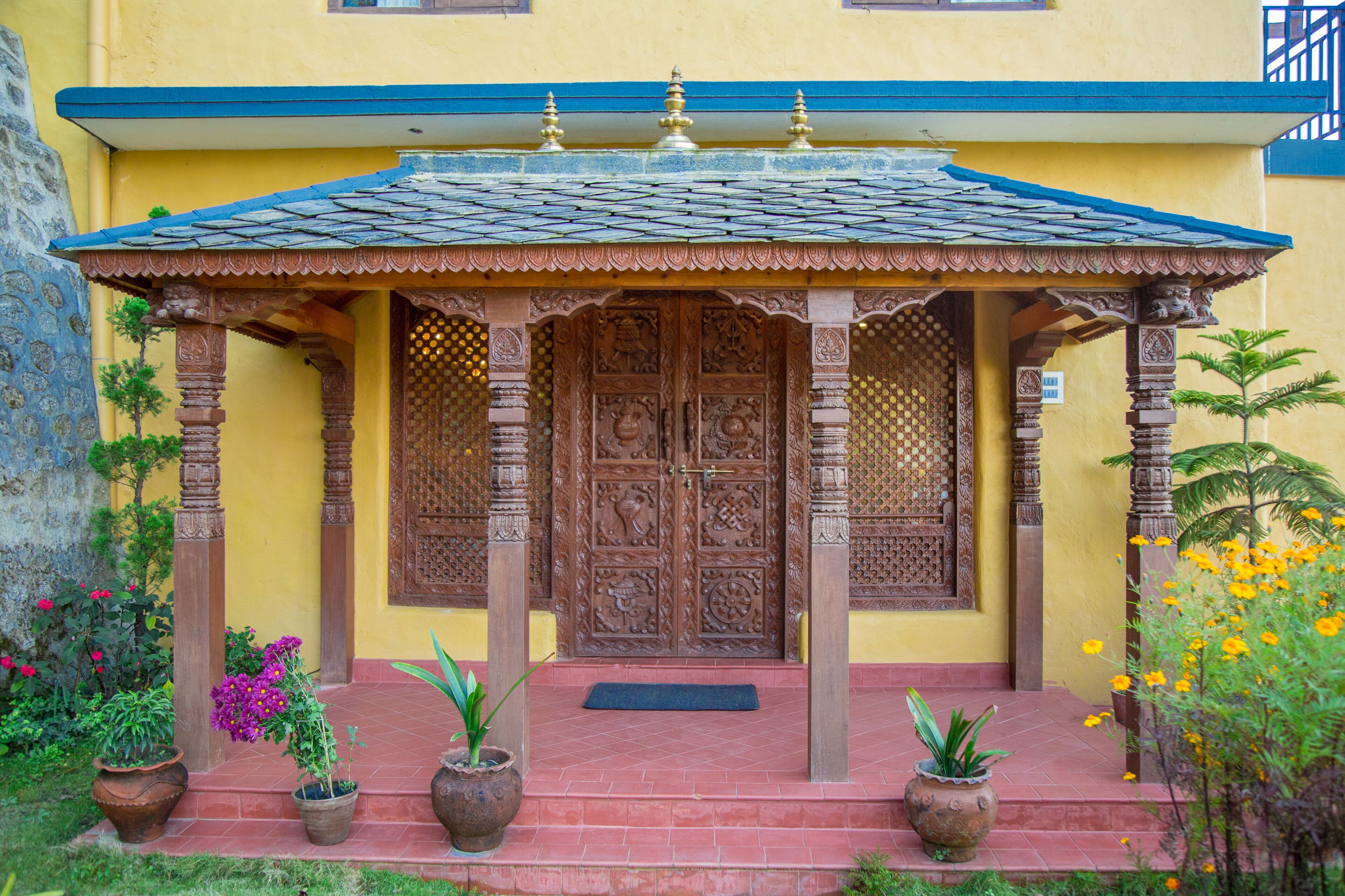 A traditional building with a wooden door, a tiled roof, and a small porch with columns.