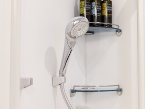 A showerhead mounted on a wall with a towel rack below it. - KOKO HOTEL Akabane Station (Tokyo)