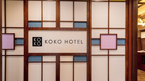 A framed sign with 'KOKO HOTEL' text, surrounded by a wooden frame with a grid pattern. - KOKO HOTEL Akabane Station (Tokyo)