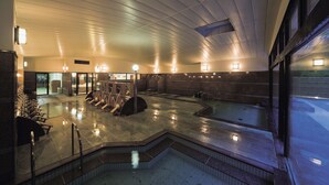 A spacious indoor swimming pool with multiple lanes, a seating area, and a well-lit ceiling. - Santoka - Kurashiki Yuga Onsen - (Kurashiki)