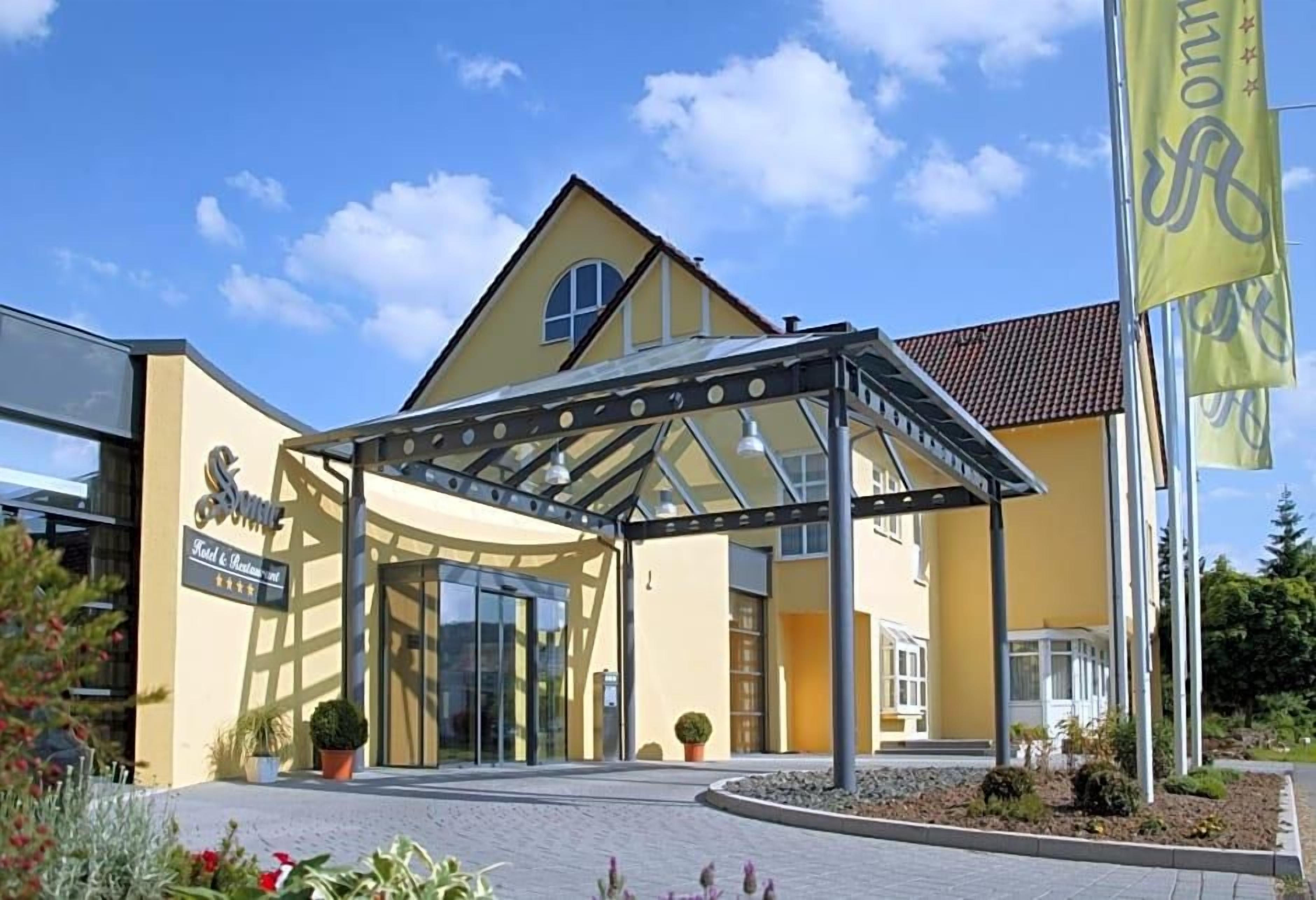 A hotel entrance with a covered walkway, a glass door, and a sign indicating a restaurant.
