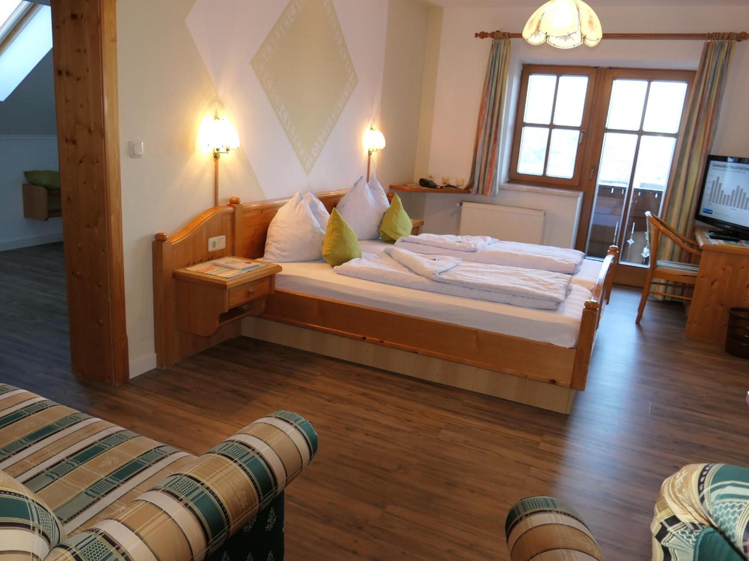 Ein Zimmer mit einem Bett, einem Nachttisch, einer Lampe und einem Fernseher.