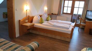 Ein Zimmer mit einem Bett, einem Nachttisch, einer Lampe und einem Fernseher.