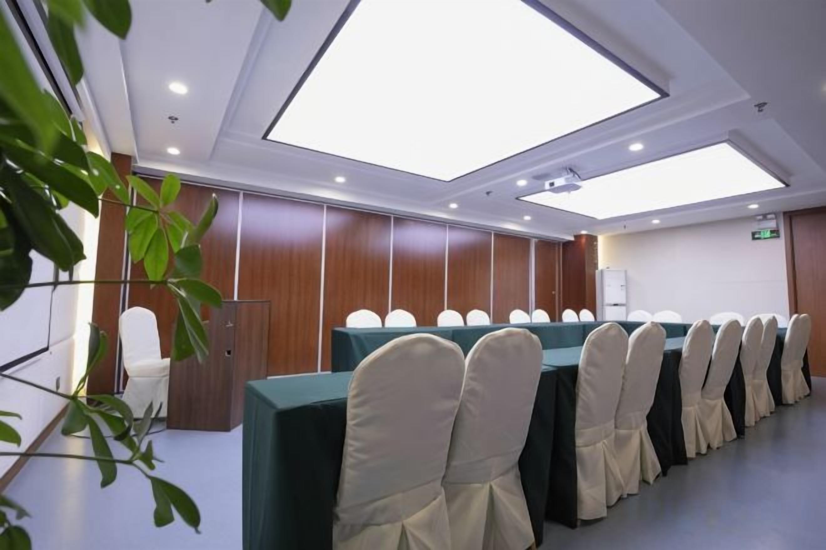 A conference room with a long table, chairs, and a ceiling skylight.