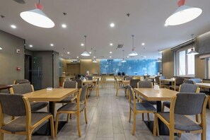 A spacious dining area with multiple tables and chairs, a counter, and a view of a cityscape. - Homeinn · neo (Qingdao Chengyang Zhengyang Middle Road Wanxianghui) (Qingdao)