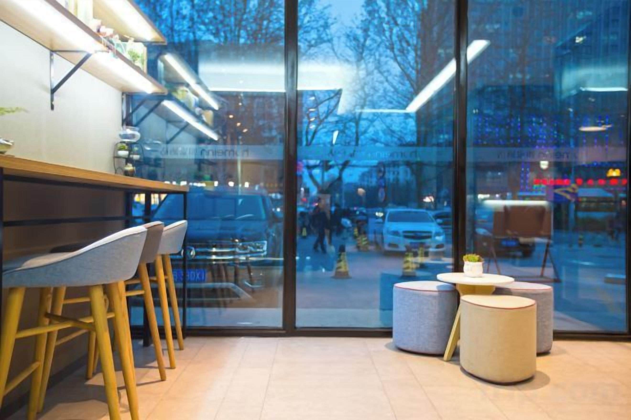 Un interior moderno con una zona de bar, asientos y ventanas amplias.