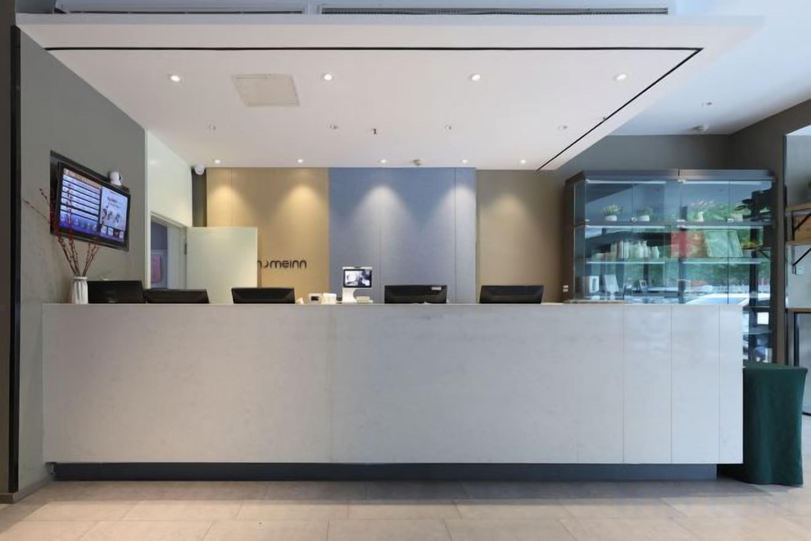 A reception desk with a flat-screen TV, a glass display case, and a modern interior design.
