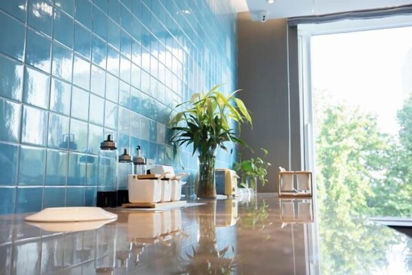 Un hall d’hôtel moderne avec une grande fenêtre, une plante en pot et un espace salon.