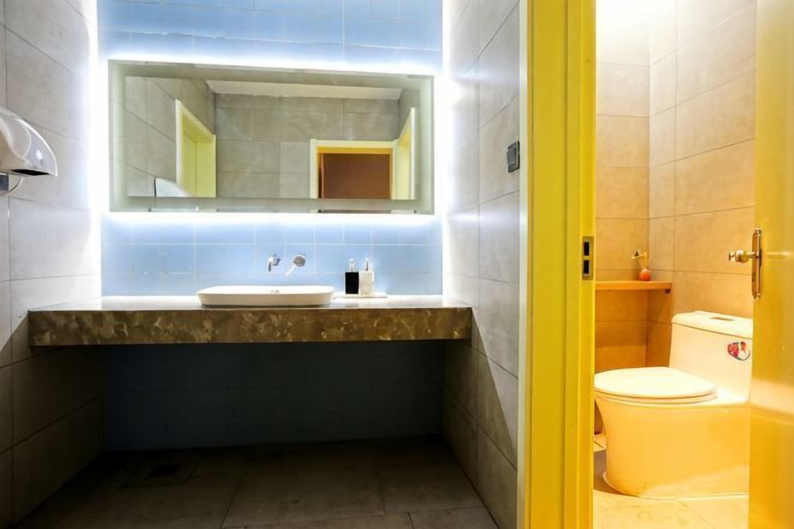 Ein Badezimmer mit Waschbecken, Spiegel und Toilette.