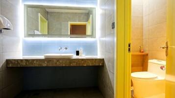 Ein Badezimmer mit Waschbecken, Spiegel und Toilette.