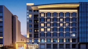 Ein modernes Hotelgebäude mit einem Raster aus Fenstern und einem markanten Eingang.