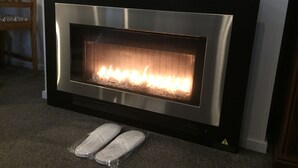 Ein moderner Kamin mit Metallrahmen und offenem Feuer.