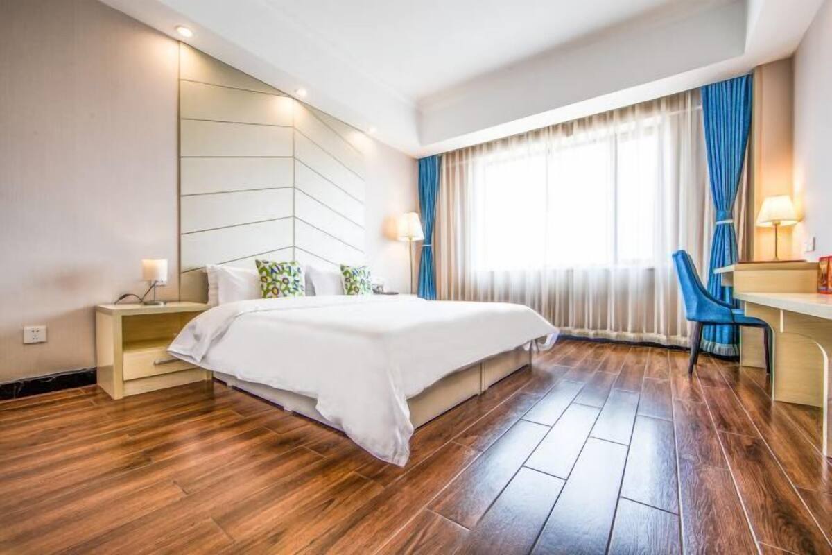Ein modernes Hotelzimmer mit einem großen Bett, einem Schreibtisch und einem Sessel.
