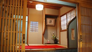 A traditional Japanese room with tatami mats, a shoji screen, a wooden altar, and a stone lantern. - Yadoya Manjiro (Kyoto)