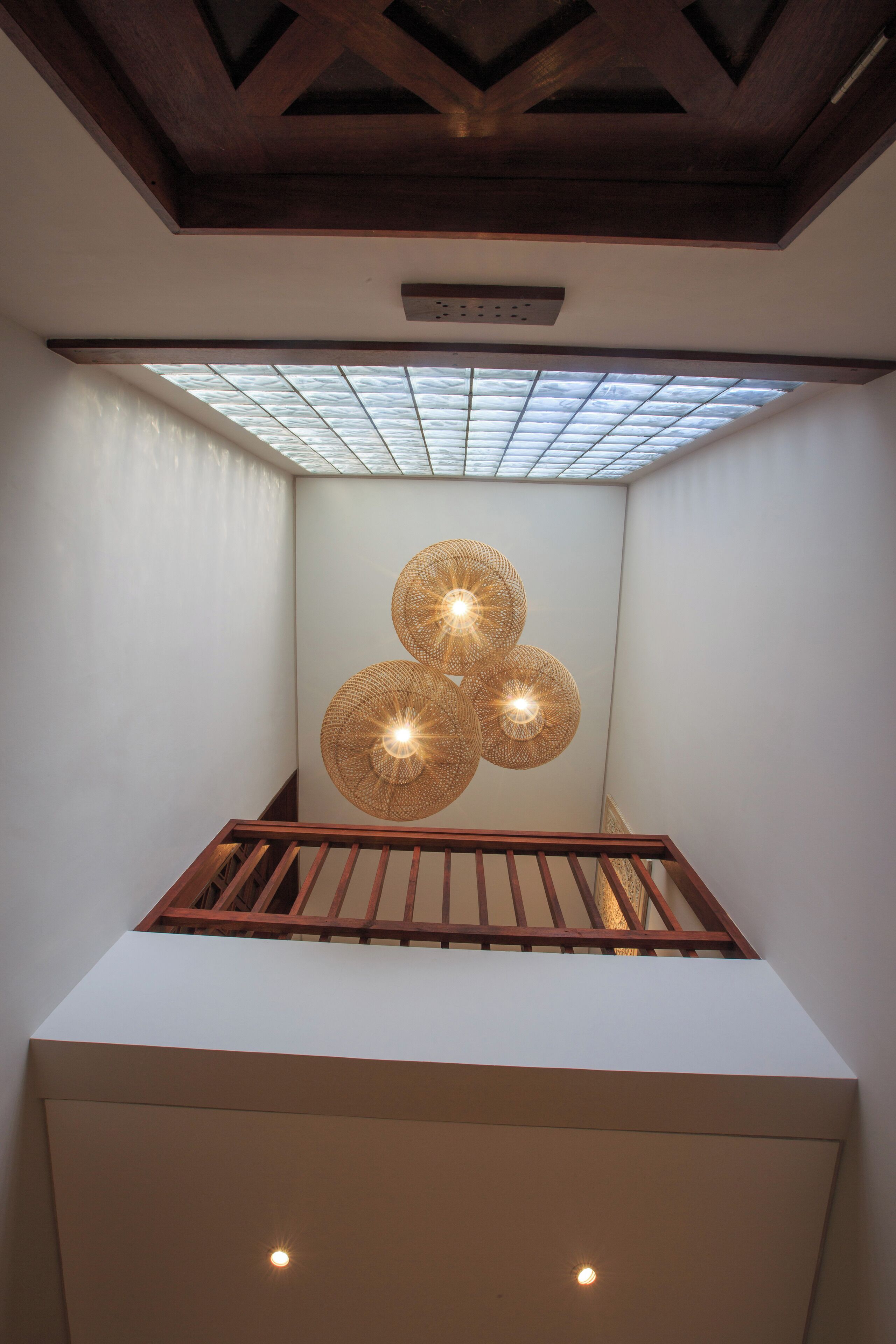 Ein modernes Interieur mit Oberlichter, einem geometrischen Wandbild und einer Holztreppe.