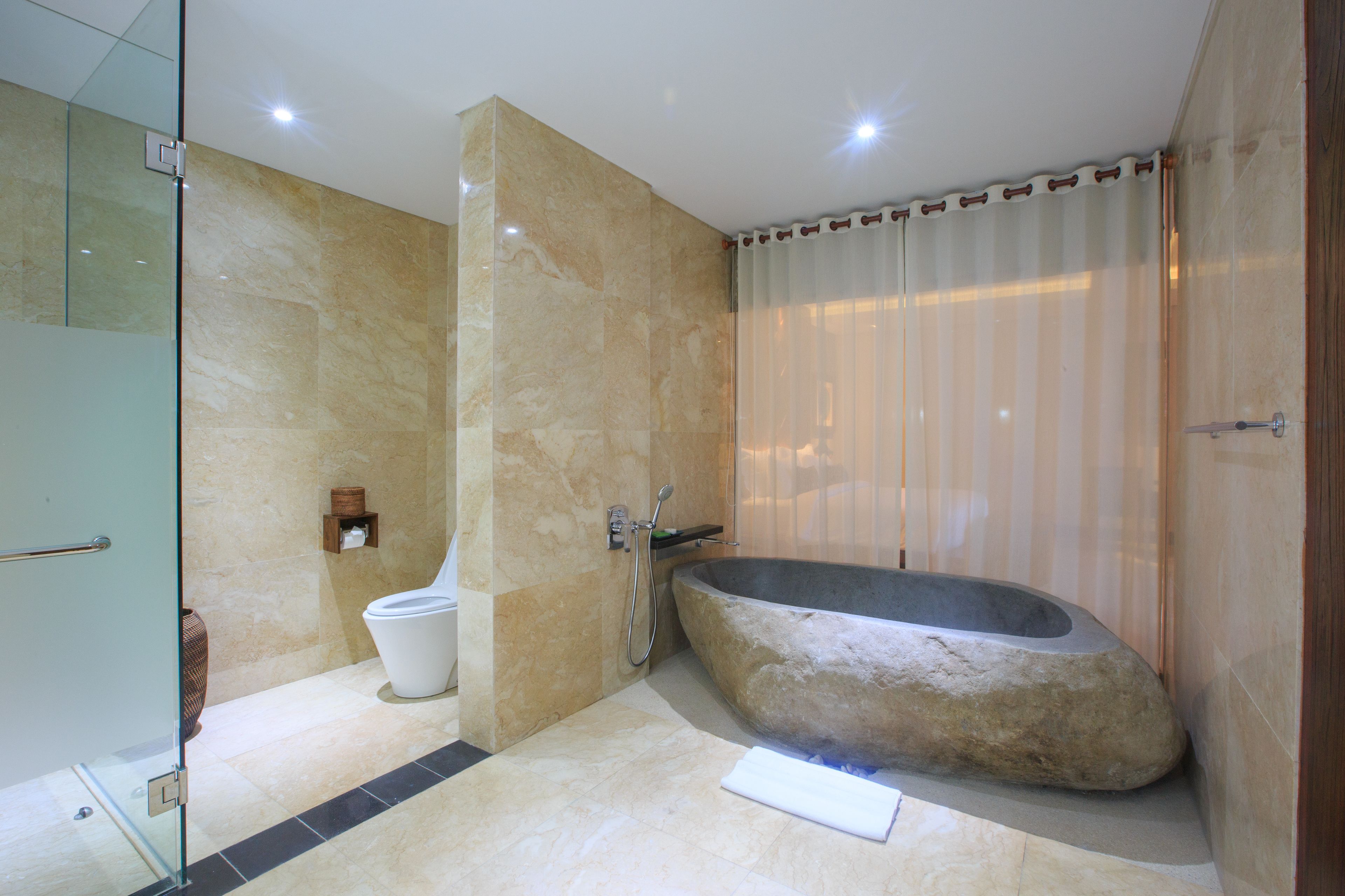 Un baño moderno con una bañera independiente, cabina de ducha de vidrio y un inodoro.