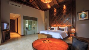 A hotel room with a large bed, a round wooden table, and a ceiling with a wooden lattice design. - Tejaprana Bisma (Ubud)