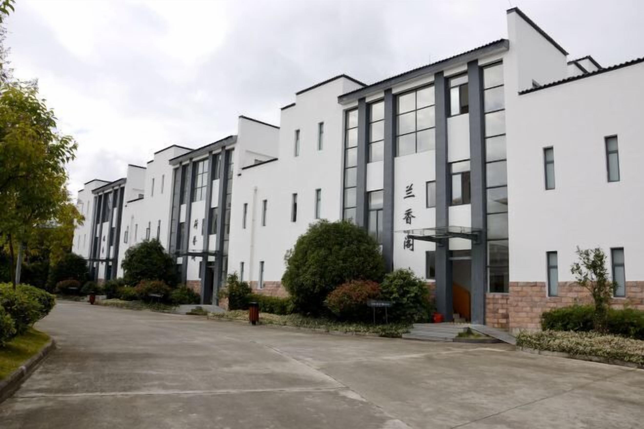 Un bâtiment moderne à la façade symétrique, doté de grandes fenêtres et d’une entrée centrale.