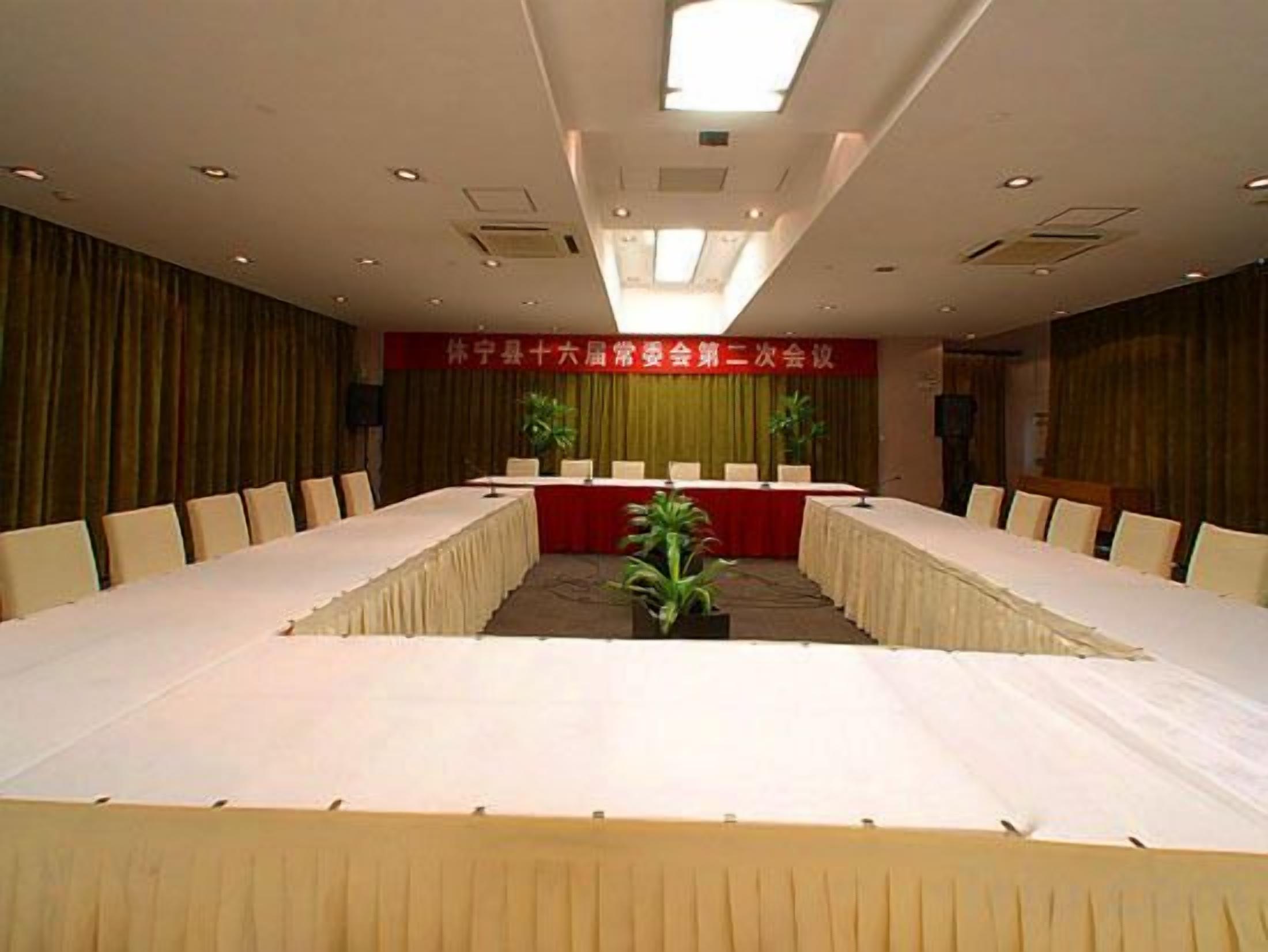 A conference room with a long table, chairs, and a podium.