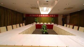 A conference room with a long table, chairs, and a podium.
