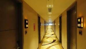 A long, narrow hotel corridor with doors on both sides, illuminated by overhead lighting. - Shenzhen Pengker Deluxe Collection Hotel (Shenzhen)