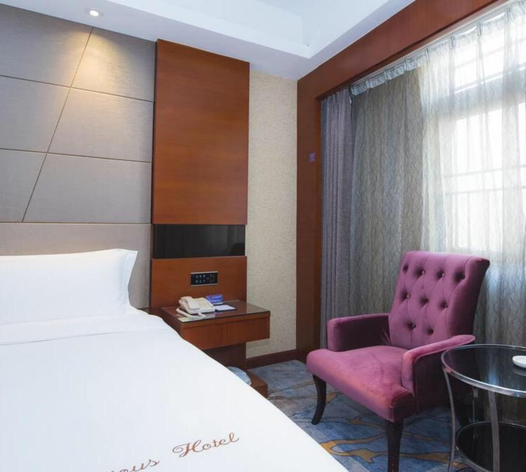 Une chambre d’hôtel comprenant un lit, une table de chevet, un téléphone, une chaise et une table.