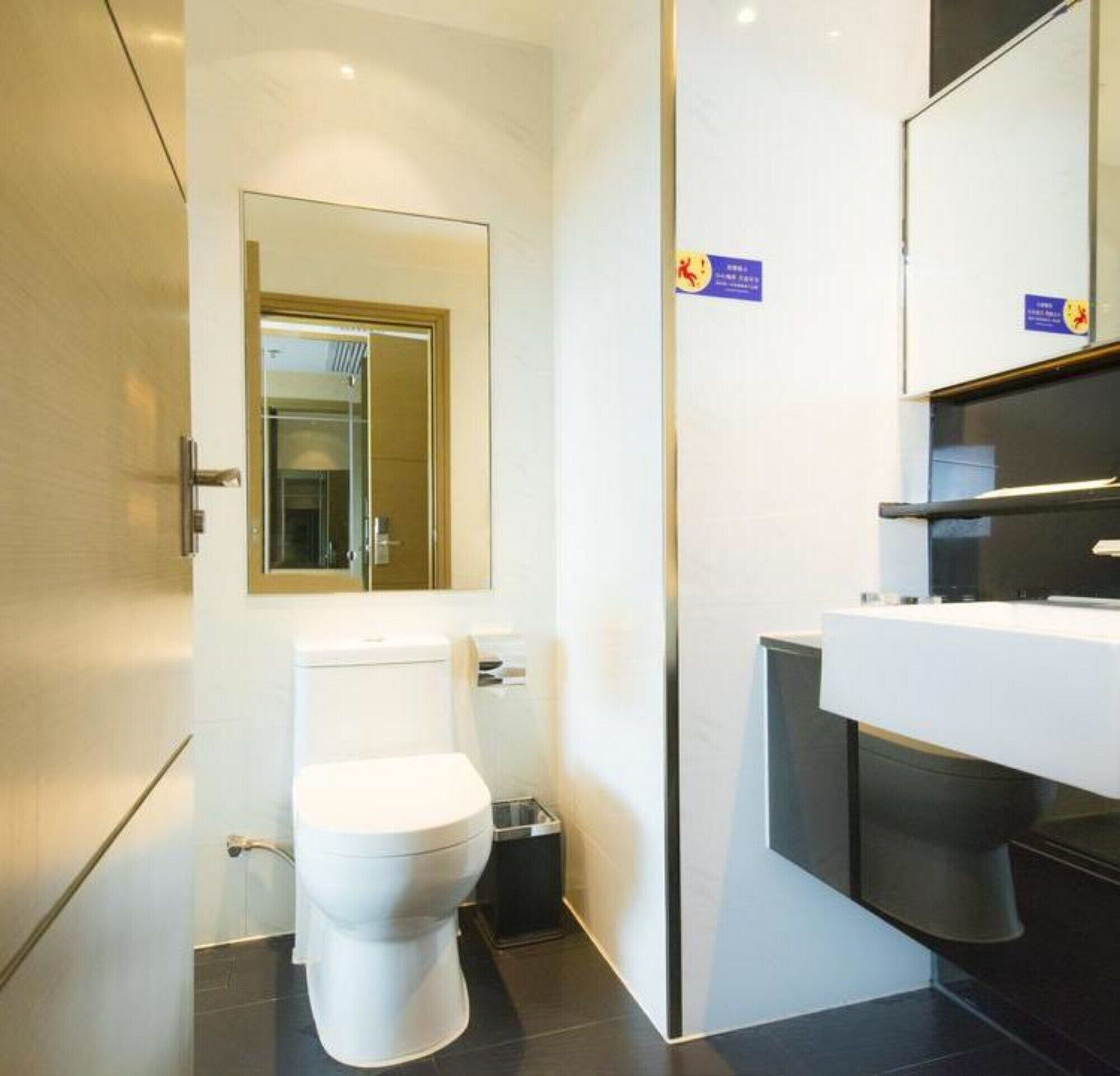 A modern bathroom with a toilet, sink, and mirror.