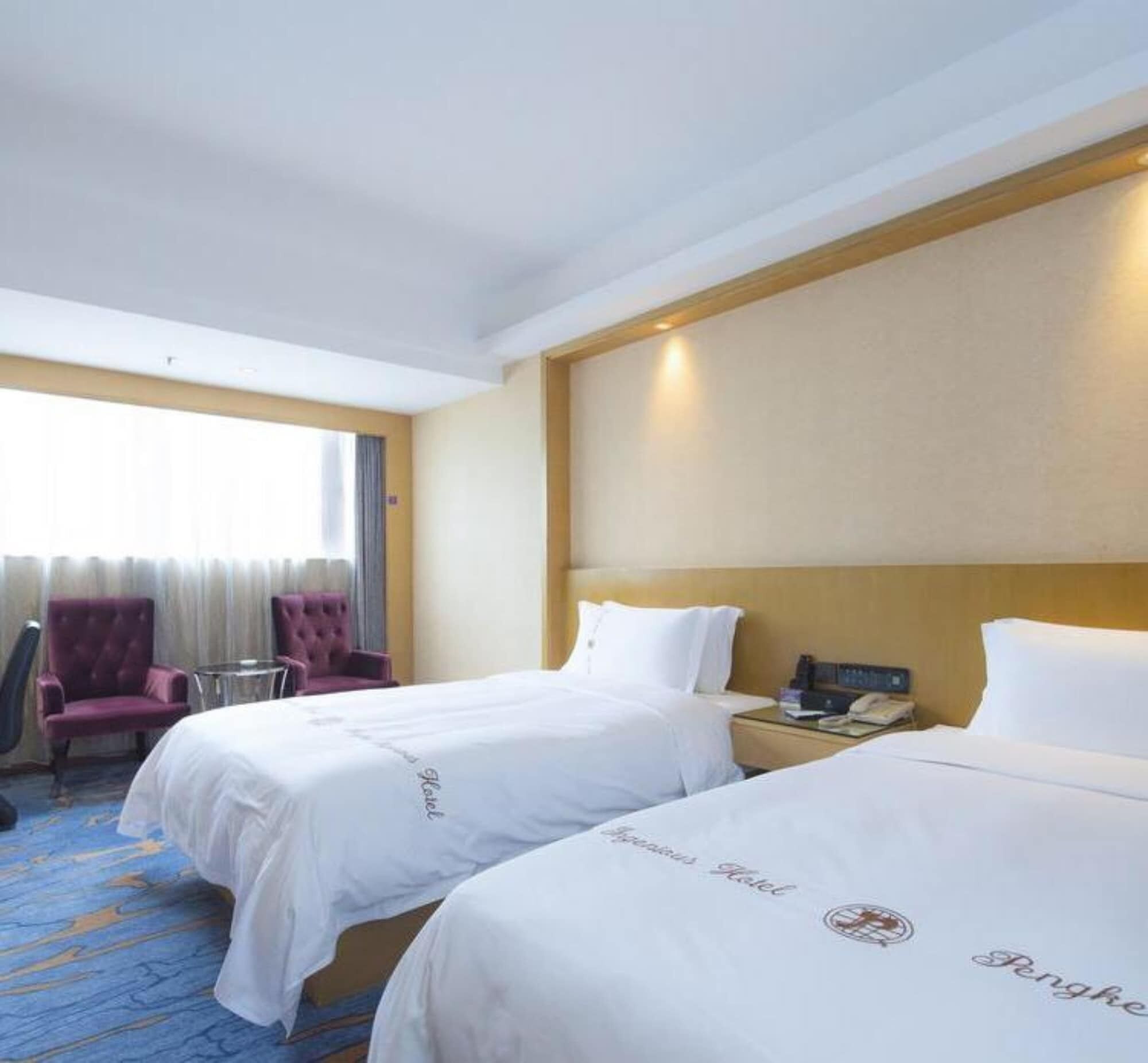 Une chambre d’hôtel avec deux lits, une petite table, une chaise et une fenêtre avec des rideaux.