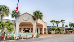 A hotel with a central fountain, palm trees, and an American flag.