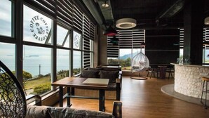 Un café moderne avec de grandes fenêtres, un plancher en bois et un comptoir en pierre.