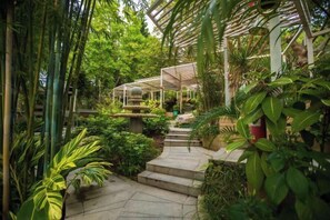 A lush garden pathway with a stone staircase leading to a covered area. - the Fountain Resort (Shenzhen)