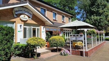 Een hotel met een bord dat aangeeft dat er een restaurant is en dat Krombacher bier wordt aangeboden.