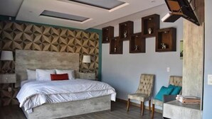 Un dormitorio moderno con una cama grande, un escritorio y una silla.