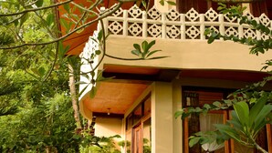 A traditional building with a balcony, surrounded by lush greenery. - Tangkoko Sanctuary Villa & Spa (Bitung)
