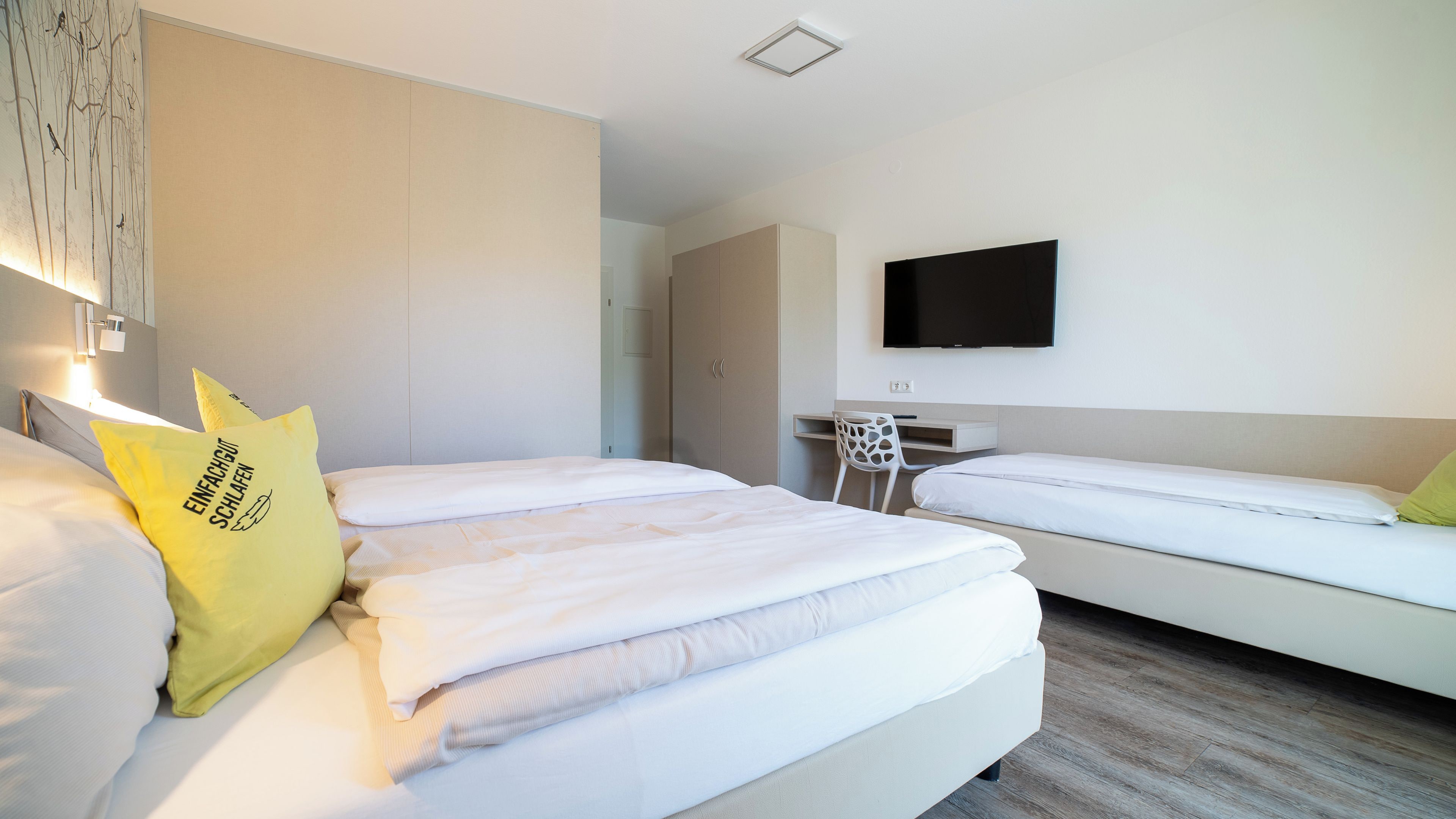 A hotel room with a bed, a desk, and a TV.