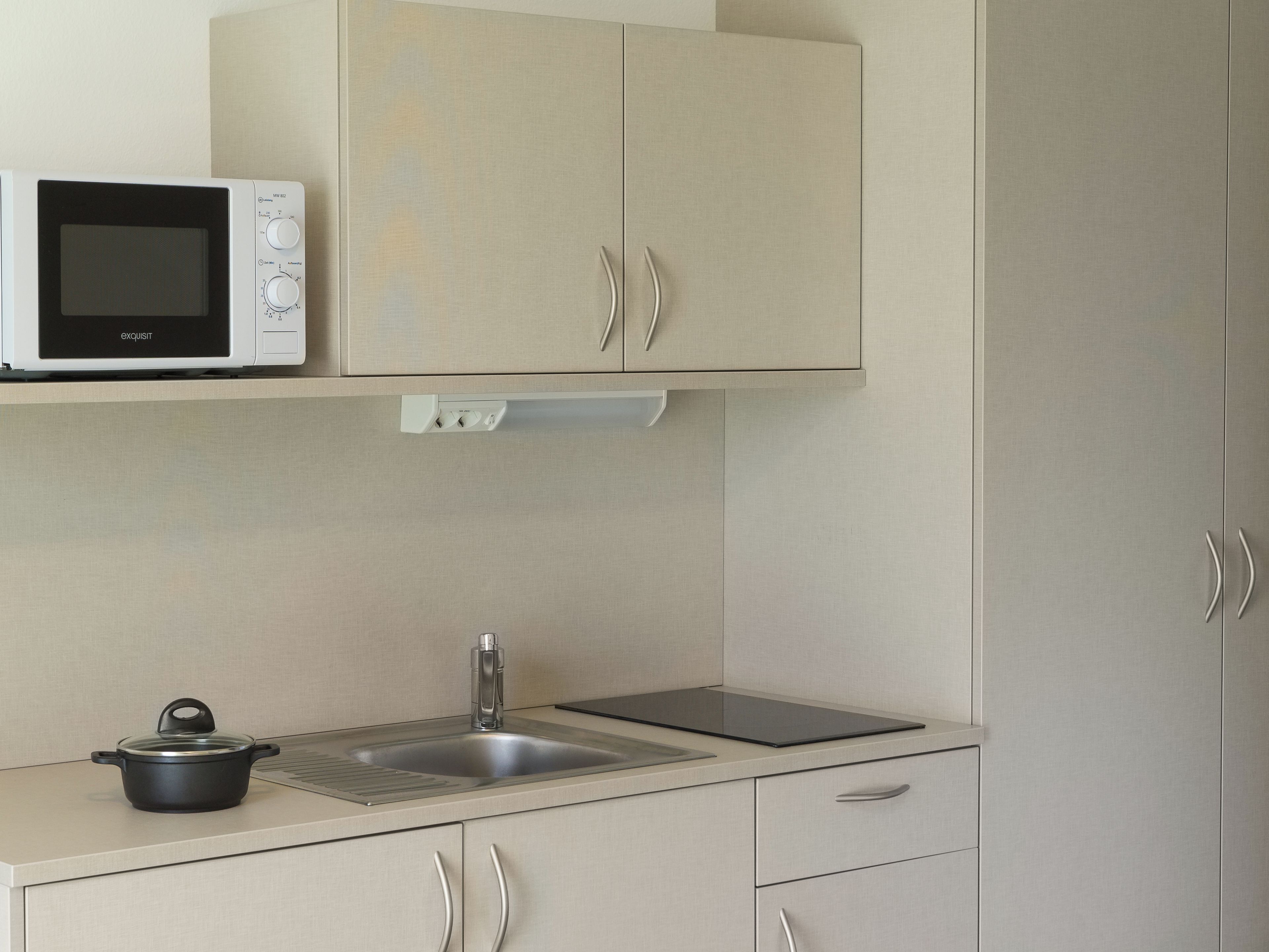 A kitchen with a microwave, a sink, and a stove.