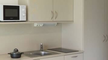 A kitchen with a microwave, a sink, and a stove.