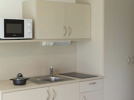 Una cocina con microondas, fregadero y estufa.