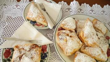 A table with plates of pastries dusted with powdered sugar, a lace tablecloth, and a timestamp.