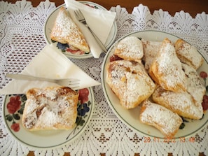A table with plates of pastries dusted with powdered sugar, a lace tablecloth, and a timestamp.