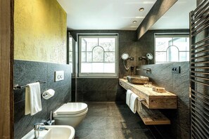 A modern bathroom with a toilet, sink, and vanity.