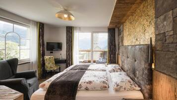 Una camera d'albergo con un letto grande, una scrivania, una sedia e un televisore.