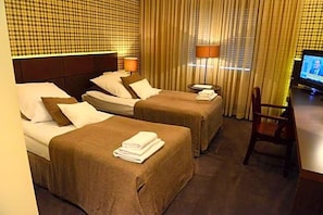 A hotel room with two beds, a television, and a desk. - Wawrzyniak (Zduny)